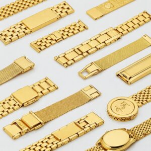 Collection of different styles of gold watch bands, from classic link to modern mesh.