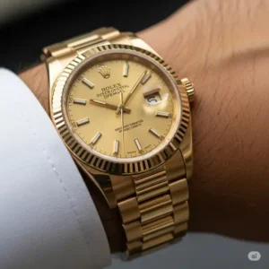 A close-up shot of a gents gold Rolex watch comfortably resting on a wrist, highlighting its luxurious presence.