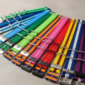 A vibrant collection of colorful nylon watch straps arranged neatly.